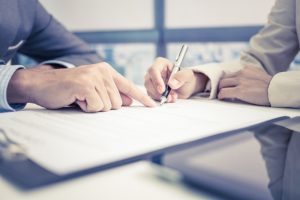 Female hand signing divorce contract