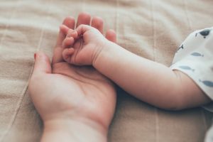 parent holding infants hand