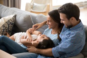 Family of three enjoying a cozy moment together on the couch
